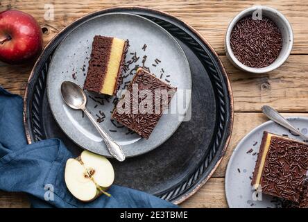 Delizioso dessert al cioccolato con ripieno di mela cremosa, condito con spruzzi croccanti Foto Stock