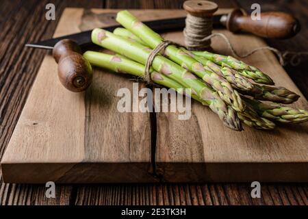Vegetale nutriente ad alto contenuto antiossidante, un mazzo di asparagi verdi freschi su rustico fondo di legno Foto Stock