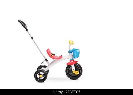 Studio di un triciclo per bambini con una spinta maniglia isolata su sfondo bianco Foto Stock