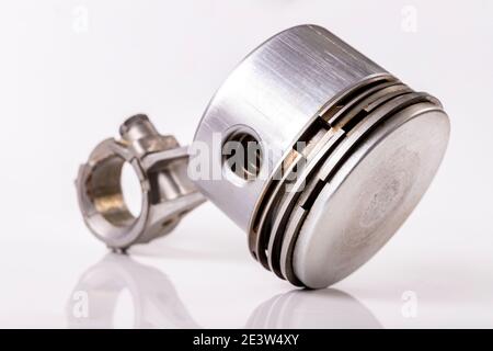 Pistone e biella di un piccolo motore a combustione interna. Pezzi di ricambio per la riparazione e la rigenerazione del motore. Sfondo chiaro. Foto Stock