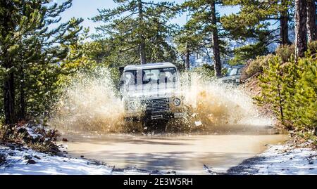 Fuoristrada nella neve nelle montagne soleggiate di Troodos Cipro con un Defender e una scoperta Foto Stock