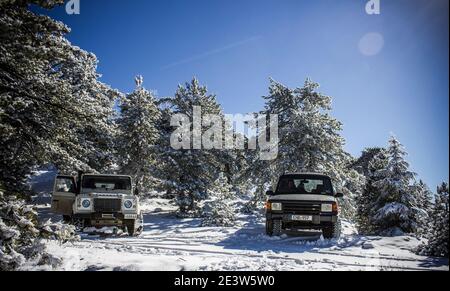 Fuoristrada nella neve nelle montagne soleggiate di Troodos Cipro con un Defender e una scoperta Foto Stock