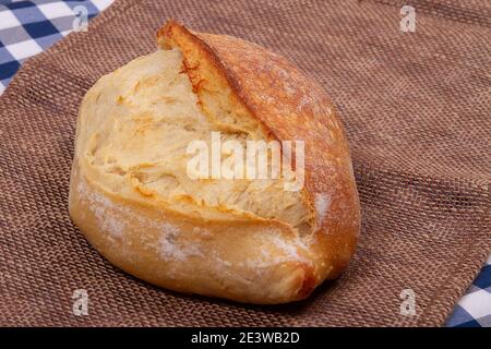 Pane di pane tradizionale francese appena sfornato in casa su rustico sfondo tessuto Foto Stock