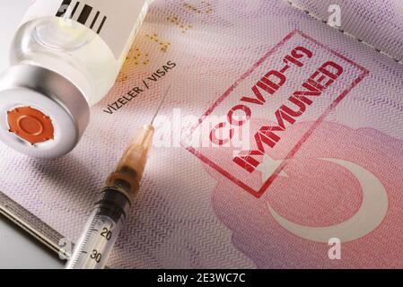 Primo piano di un flacone di vaccino del coronavirus e di una siringa con un passaporto dei Turkeys come passaporto del vaccino Covid 19 testo immune scritto sulla pagina. Foto Stock