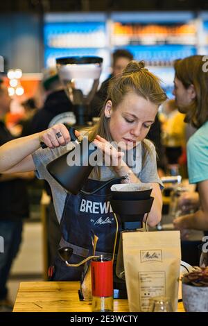 barista femminile che versa il caffè attraverso il filtro melitta Foto Stock