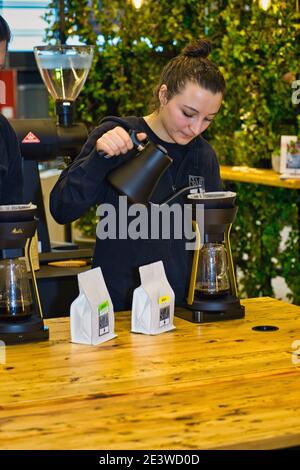 barista femminile che versa il caffè attraverso il filtro melitta Foto Stock