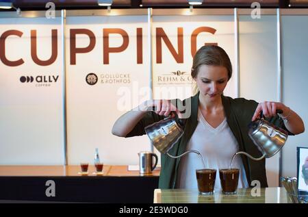 Barista femminile che versa acqua in una tazza di caffè macinato Foto Stock