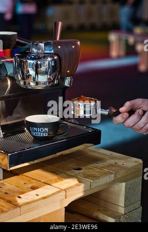 Portafiltro per mani con caffè macinato di macchina per espresso Foto Stock