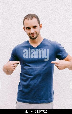 uomo che indossa una maglietta blu mockup all'aperto Foto Stock