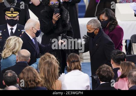 Il presidente eletto degli Stati Uniti Joe Biden, a sinistra, saluta l'ex presidente degli Stati Uniti Barack Obama, a destra, con un pugno durante l'inaugurazione presidenziale 5nono a Washington, DC, Stati Uniti, mercoledì 20 gennaio 2021. Biden proporrà un’ampia revisione dell’immigrazione il suo primo giorno di presidente, che includerà un percorso abbreviato verso la cittadinanza statunitense per i migranti non documentati - un’inversione di rotta totale rispetto alle restrizioni e ai blocchi di immigrazione di Donald Trump, ma che si trova ad affrontare i principali blocchi stradali del Congresso. Fotografo: Kevin Dietsch/UPI/MediaPunch Foto Stock