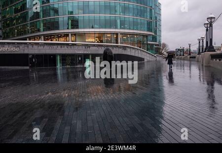 Londra, Regno Unito. 20 gennaio 2021. Una signora che tiene un ombrello che cammina lungo la Scoop a More London Riverside, a Londra, Regno Unito il 20 gennaio 2021. MET Office prevede che l'unica giornata di sole a Londra nei prossimi 7 giorni dovrebbe essere il Venerdì 22 gennaio Credit: May James/ZUMA Wire/Alamy Live News Foto Stock