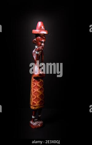 Scultura africana tradizionale di un uomo in legno colorato. Foto Stock