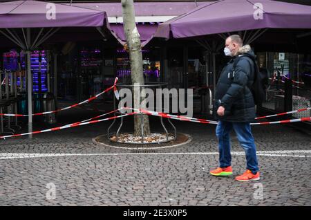 Francoforte, Germania. 20 gennaio 2021. Un pedone con una maschera facciale cammina davanti a una caffetteria chiusa durante la pandemia COVID-19 a Francoforte, Germania, 20 gennaio 2021. I governi federali e statali tedeschi hanno concordato martedì sera di estendere le attuali misure COVID-19 almeno fino al 14 febbraio. La maggior parte dei negozi e delle scuole rimarrà chiusa e le persone continueranno a essere invitate a limitare i loro contatti e a rimanere a casa il più possibile per le prossime settimane. Credit: LU Yang/Xinhua/Alamy Live News Foto Stock