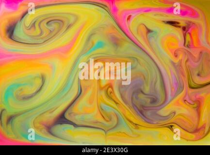 I liquidi colorati si mescolano insieme in un fluido creando uno sfondo astratto colorato Foto Stock