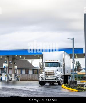 Carrello semirimorchio commerciale Big RIG White Day Cab per uso locale consegne con rimorchio a scatola lunga e griglia di protezione in piedi la stazione di rifornimento carburante ta Foto Stock