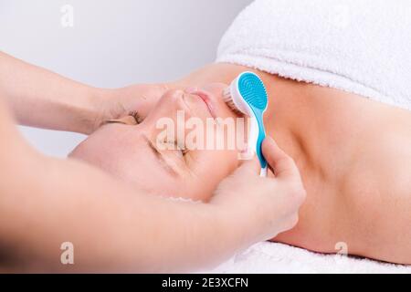 Foto ingrandita della donna anziana e massaggio viso con massaggiatore cosmetico. Cura della pelle, spa e concetto di bellezza. Foto Stock