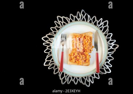 Fagioli cotti in salsa di pomodoro su toast marrone. Foto Stock