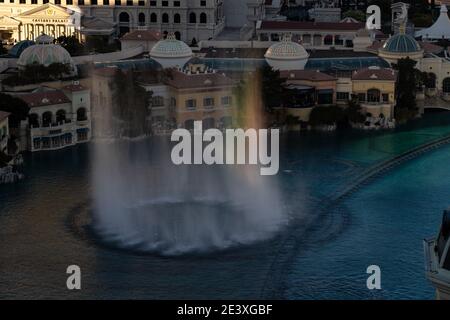 Le fontane di Bellagio rivelano piccoli arcobaleni come il sole Inizia a partire dalla Strip di Las Vegas Foto Stock