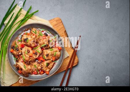 Dim Sum maiale costolette di ricambio o Pai Guat in ciotola grigia su piano tavolo in cemento scuro. Cucina cinese cantonese piatto di Spareribs al vapore con soia nera. ASI Foto Stock