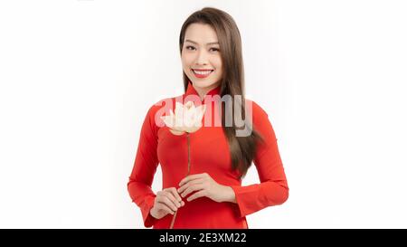 Belle ragazze vietnamite vestito tradizionale Ao dai vestito rosso. Ragazza vietnamita che tiene un fiore di loto Foto Stock