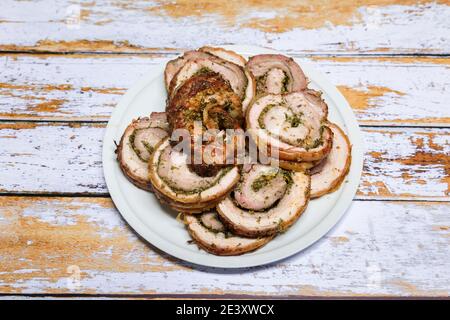 Porchetta ben grigliata tagliata a fette in un piatto e. pronto a servire Foto Stock