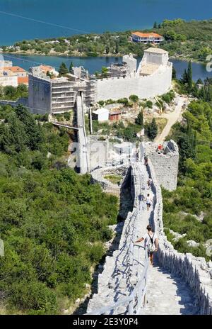 Croazia: Ston. Turisti sulle fortificazioni della Grande Muraglia di Ston, la più lunga d'Europa. Qui a Mali Ston, lato nord dell'Istmo di Peljes Foto Stock