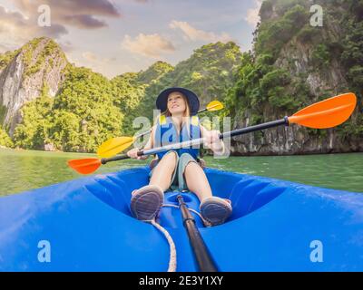 I viaggiatori di mamma, papà e figlio che girano su un kayak nella Baia di ha Long. Vietnam. Viaggio in Asia, emozione di felicità, concetto di vacanza estiva. Viaggiare con Foto Stock