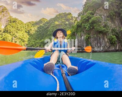 I viaggiatori di mamma, papà e figlio che girano su un kayak nella Baia di ha Long. Vietnam. Viaggio in Asia, emozione di felicità, concetto di vacanza estiva. Viaggiare con Foto Stock