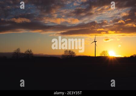 Silhouette nera del generatore di energia delle turbine a vento su tramonto stupefacente ad una fattoria di vento a langenberg, germania Foto Stock