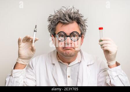 Scienziato pazzo con capelli grigi che eseguono esperimenti in laboratorio Foto Stock