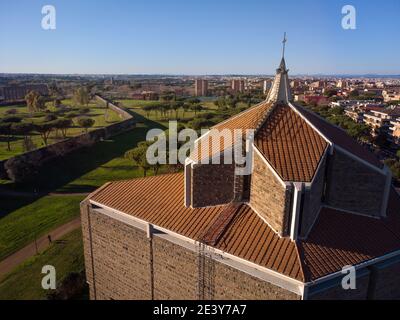 La croce della chiesa di San Policarpo in primo piano. Sullo sfondo lo skyline di Roma vicino al Parco degli Acquedotti, uno dei più grandi e ol Foto Stock