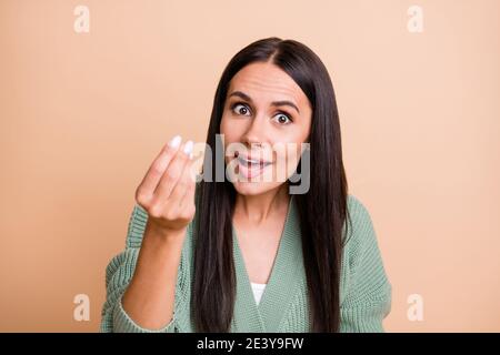 Ritratto di ragazza ottimista chiedere soldi indossare felpa verde isolato su sfondo color pesca Foto Stock