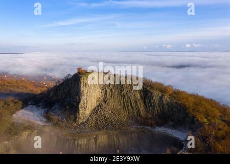 Monoszló, Ungheria - Vista aerea della formazione vulcanica di basalto chiamata Hegyestű con nebbia sul lago Balaton Foto Stock