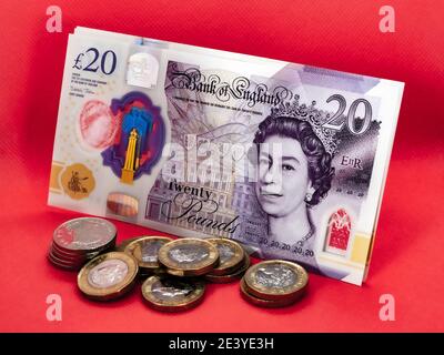Primo piano di nuove banconote da £20 da 20 libbre con monete in sterline davanti. Questa denominazione di banconote in polimero è entrata in circolazione in Gran Bretagna nel 2020. Foto Stock