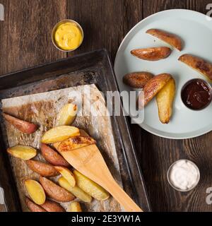 Patate rustiche al forno a forma di latta sul tavolo da pranzo. Vista dall'alto Foto Stock