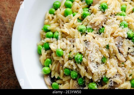 pesto di piselli verdi e pasta di orzo e funghi saltati Foto Stock