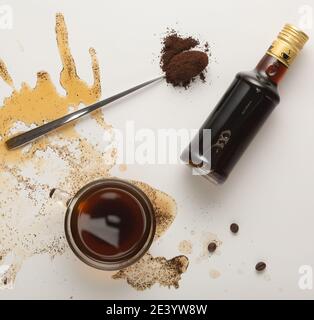 Concetto di caffè con caffè in tazza, chicchi di caffè e sciroppo di panna irlandese isolati su sfondo bianco, vista dall'alto Foto Stock
