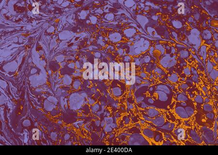 Bella miscela di vernice viola e vernice oro su un tela Foto Stock