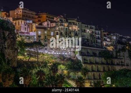 Vista panoramica notturna con edifici illuminati costruiti sulle scogliere di Tropea, Calabria, Italia Foto Stock