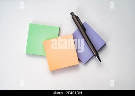 Vista dall'alto della nota adesiva e della penna sulla superficie bianca Foto Stock