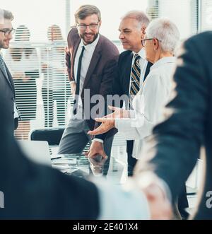 primo piano. gli uomini d'affari scuotono le mani in piedi in ufficio. Foto Stock