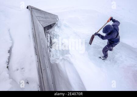 Sciatori in una spedizione di sci alpinismo scavando una neve Capanna legata nelle montagne della Norvegia Foto Stock