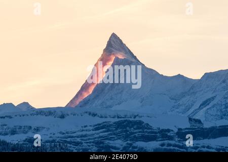 Picco di Finsteraarhorn all'alba con nuvole rosse in inverno Foto Stock