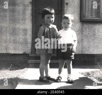 Ragazza e un ragazzo fuori casa prefabbricata, Leeds, !960's. Foto Stock