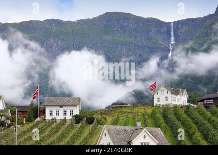 Ullensvang città in Norvegia. Montagne Misty e una cascata. Paesaggio norvegese. Foto Stock