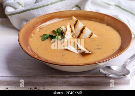 Ciotola di zuppa di fagioli servita con pane pita su sfondo di legno bianco, pasto vegano sano, cibo a base di piante Foto Stock