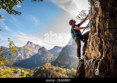 Via ferrata a Mont-Sixt-Fer-a-Cheval (Alpi francesi). Giovane donna sulla via ferrata, un mix tra trekking e alpinismo aiutato da corde corte, c Foto Stock