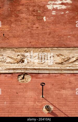 In decadimento fregio decorativo intorno a una parete rossa edificio, Hvar, Dalmazia, Croazia Foto Stock