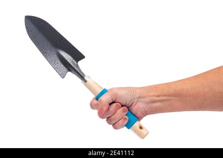 Ripresa orizzontale di una mano di una donna anziana che tiene una cazzuola da giardinaggio su uno sfondo bianco con spazio per la copia. Foto Stock