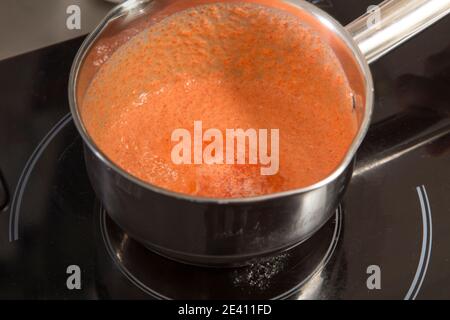 Fare ganache sulla base di peperoni al forno purè. Primo piano. Foto Stock